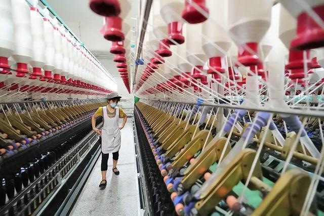 8月23日,在哈密康泰纺织有限责任公司生产车间里,工人在细纱生产机器